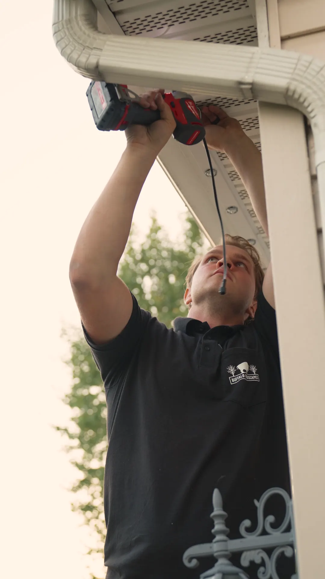 Installer fastening the channel under a soffit